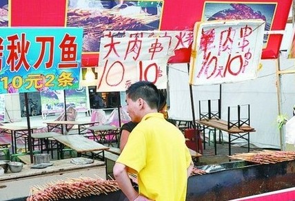 被查后，美食街上的'羊肉串'的'羊'字被涂抹了。