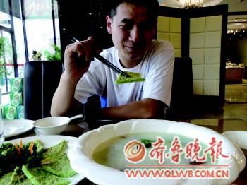 一位顧客在品嘗滸苔菜品。