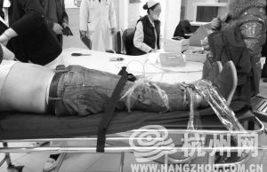 前晚10點(diǎn)52分，浙醫(yī)二院急診室，發(fā)酒瘋的小吳被家人綁在擔(dān)架上。記者 葛丹娣 攝