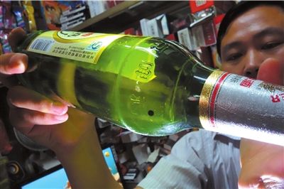 這瓶未開封的燕京啤酒內(nèi)有一顆黑色懸浮物。京華時報記者 徐曉帆 攝