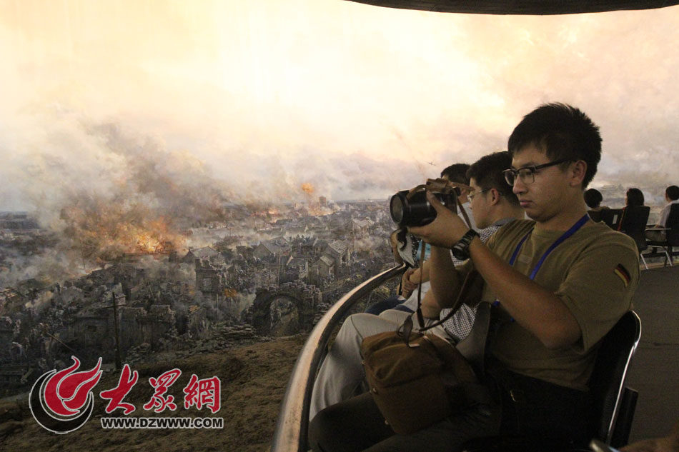 在參觀完菏澤市博物館后，西線采訪團來到菏澤冀魯豫邊區(qū)革命紀念館采訪。圖為記者們在觀看模擬戰(zhàn)爭場面。