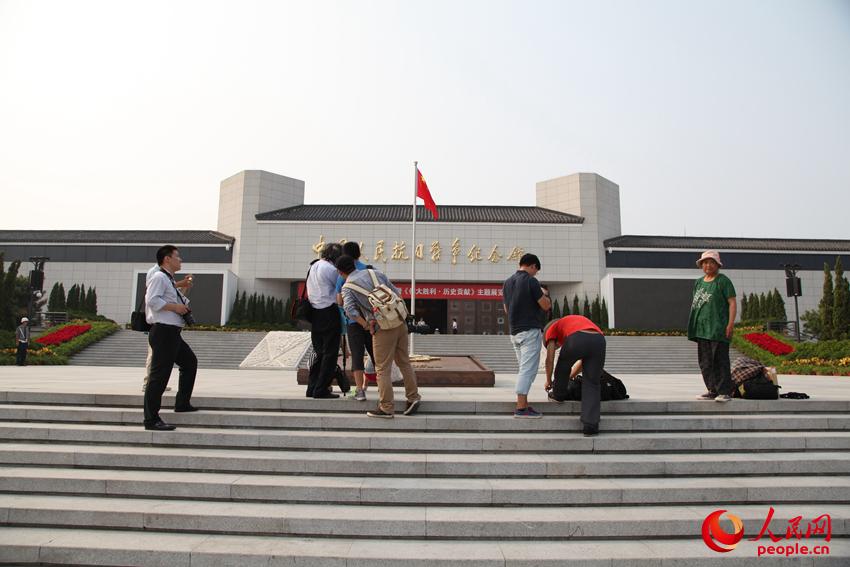 參觀展覽的觀眾在紀(jì)念館前拍照留念。邱越攝